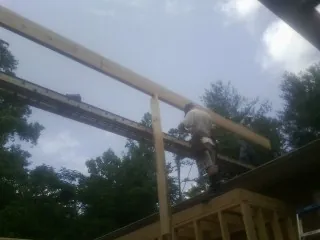 Carpenter setting a ridge beam over a new addition frame — Ice Dam Removal by Roofing Brothers in Palm Springs