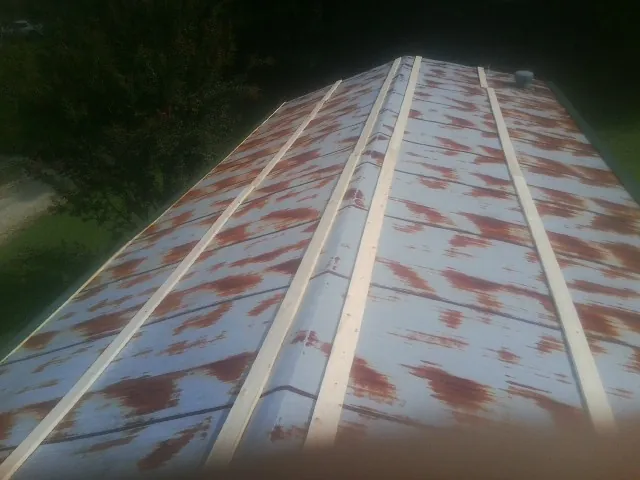 Rusted metal roof panels with new wood purlins before replacement — Storm Damage Roof Repair in Palm Springs by Roofing Brothers