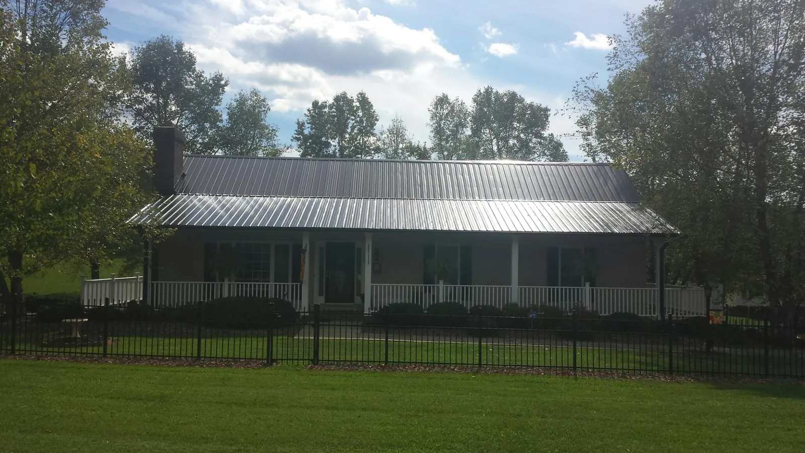Gray metal roof on a brick ranch with a full width front porch — Gutter Guard Installation work by our crew in Palm Springs